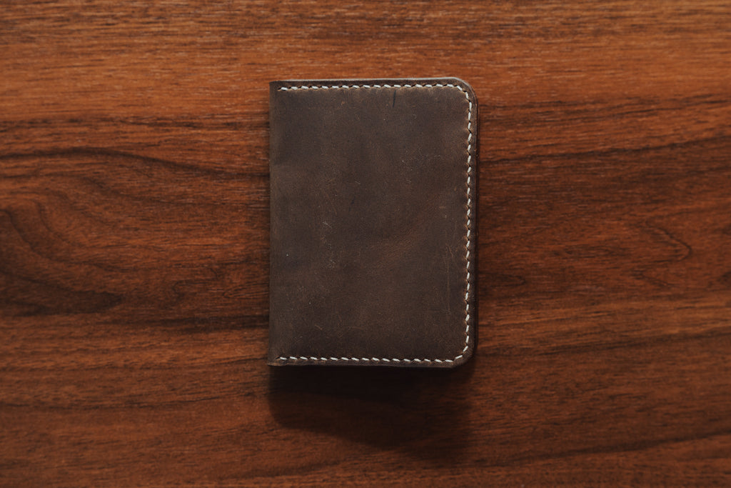 Brown leather wallet on a wooden surface