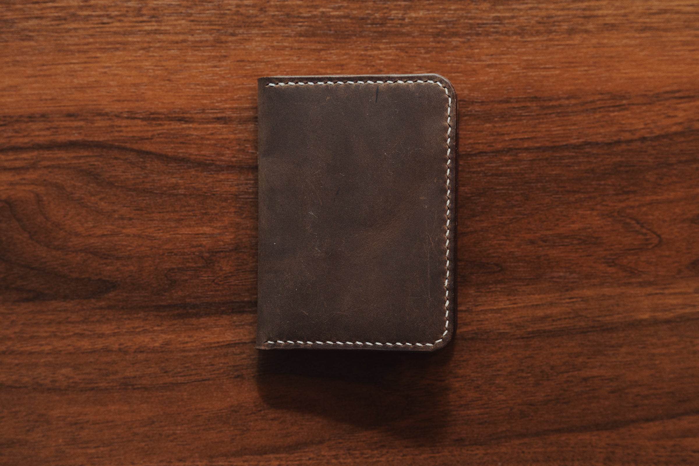 Brown leather wallet on a wooden surface