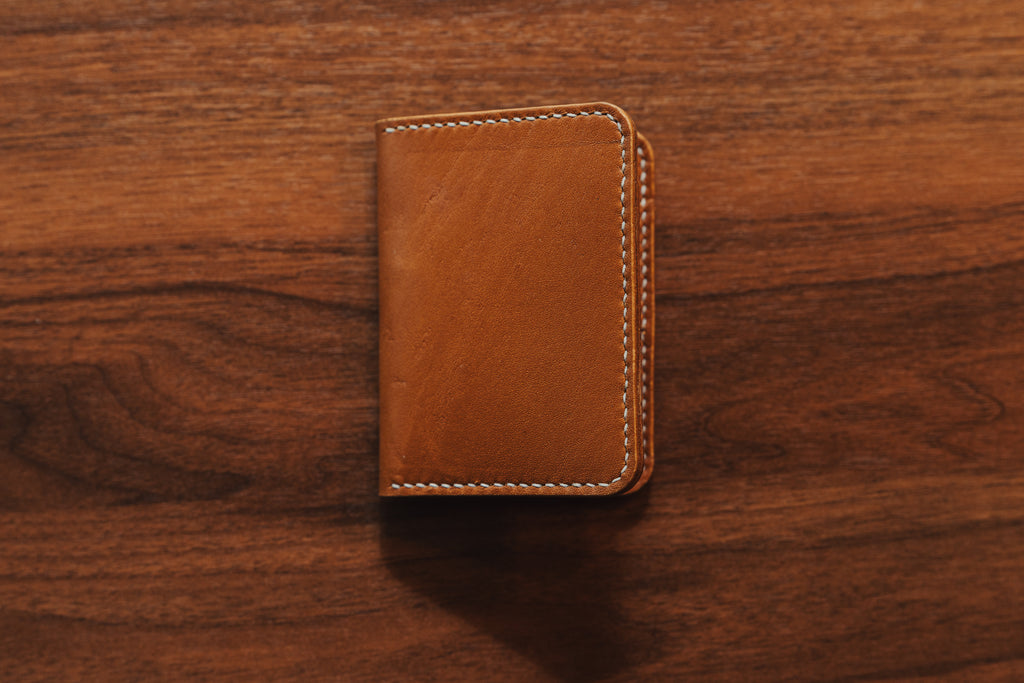 Brown leather wallet on a wooden surface