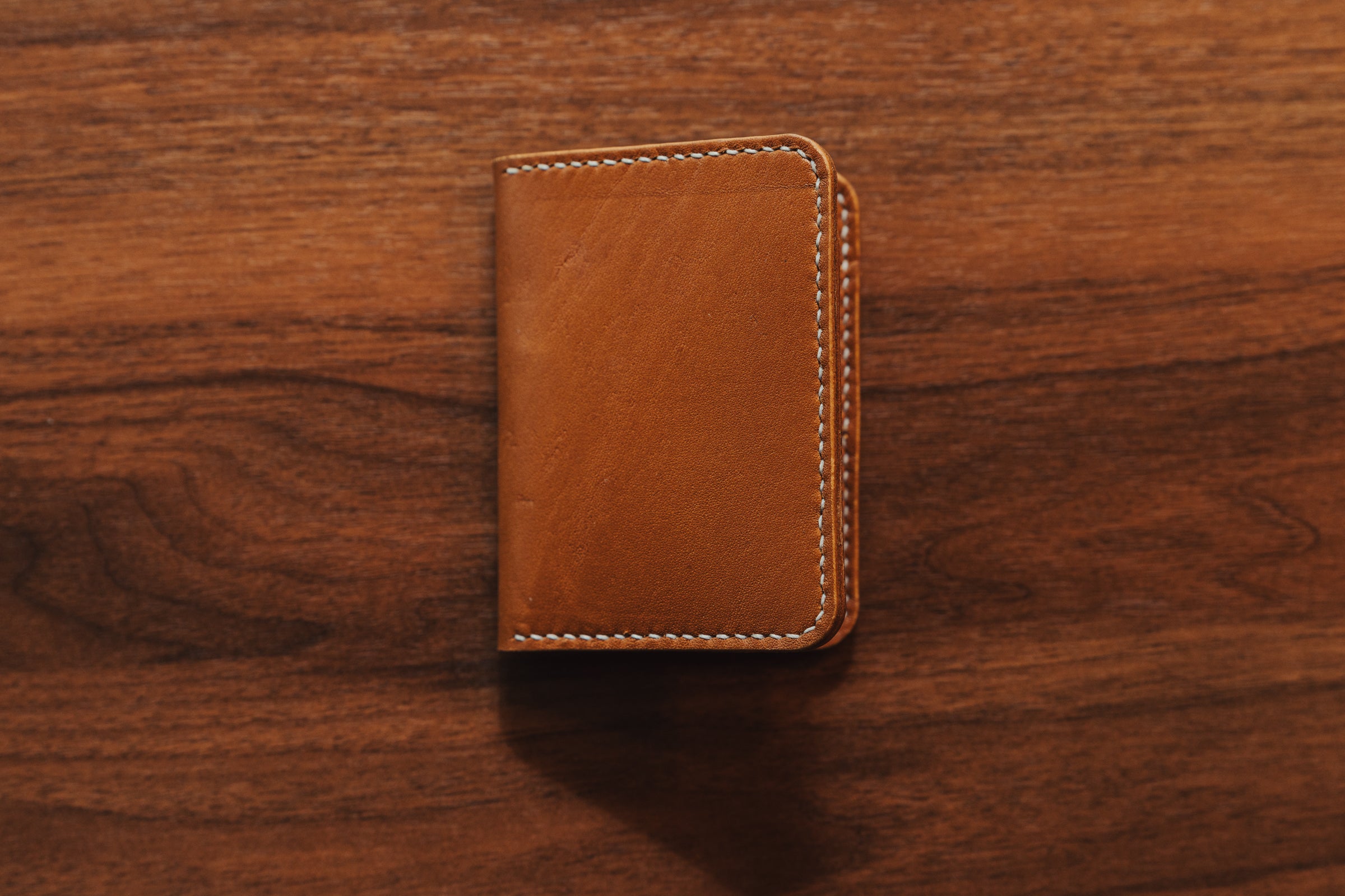 Brown leather wallet on a wooden surface